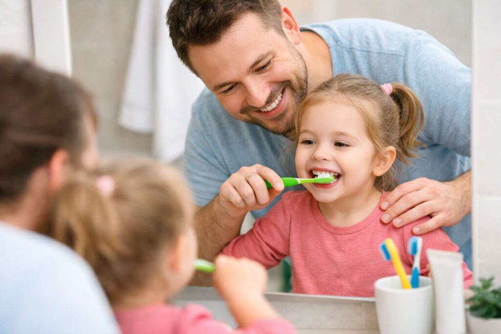 στοματική υγιεινή παιδιών με βοήθεια γονιού στο βούρτσισμα