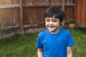 boy smiling and showing his missing teeth. Kid boy lost front milk tooth,kid play with soap bubble.